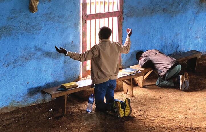 Men praying together in a small chapel